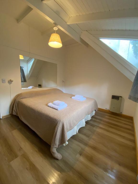 ein Schlafzimmer mit einem großen Bett im Dachgeschoss in der Unterkunft Casa Cipres in San Martín de los Andes
