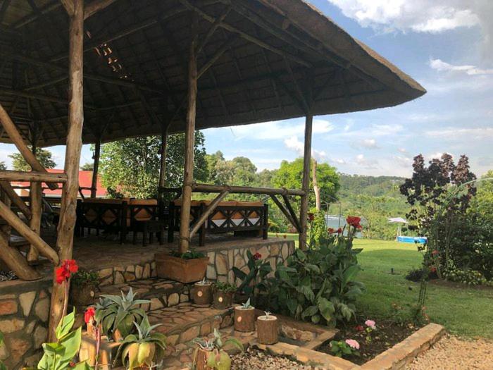 Nileit Campsite Jinja في جينجا: جناح كبير مع طاولة وبعض النباتات