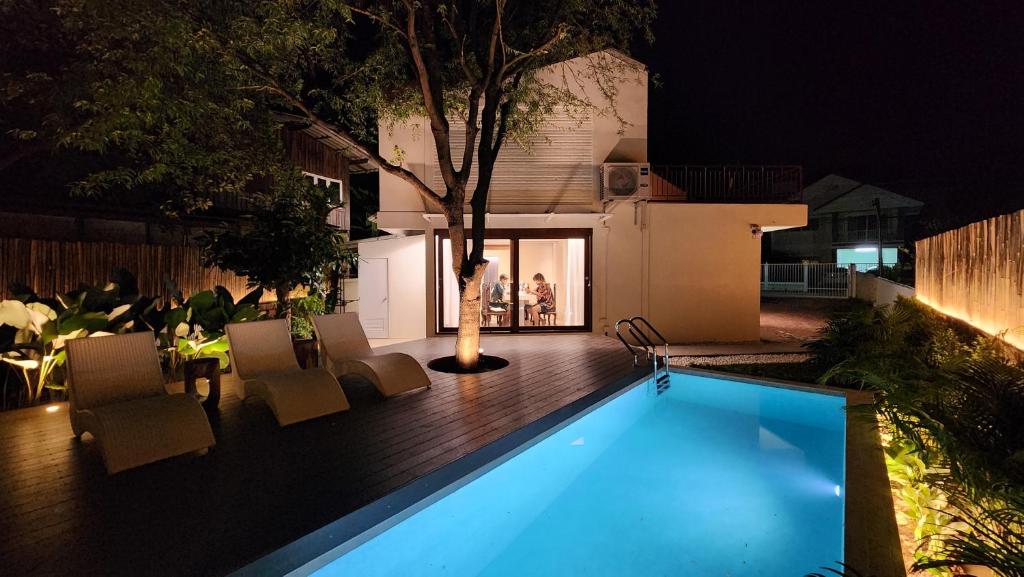 - une piscine dans un jardin la nuit dans l'établissement Sense of Haiya, à Chiang Mai