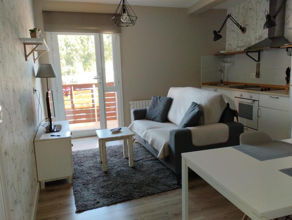 uma sala de estar com um sofá e uma mesa em CASA LAXE DO BARRO em Cangas