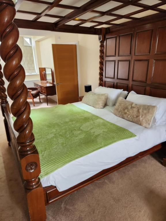 a bedroom with a large bed with a wooden headboard at The Garden Bar Rooms in Baildon