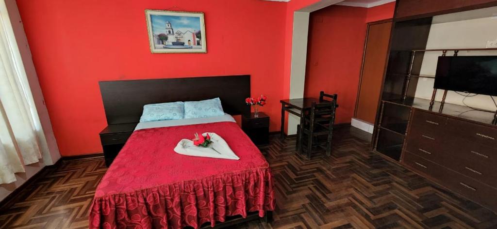 Habitación roja con cama con pared roja en HOSPEDAJE CALLAO, en Tacna