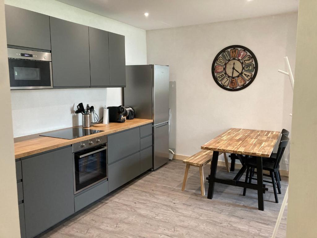 a kitchen with a table and a clock on the wall at T2 Le Conquet &quot;Molène&quot; avec parking privé 300m commerces in Le Conquet