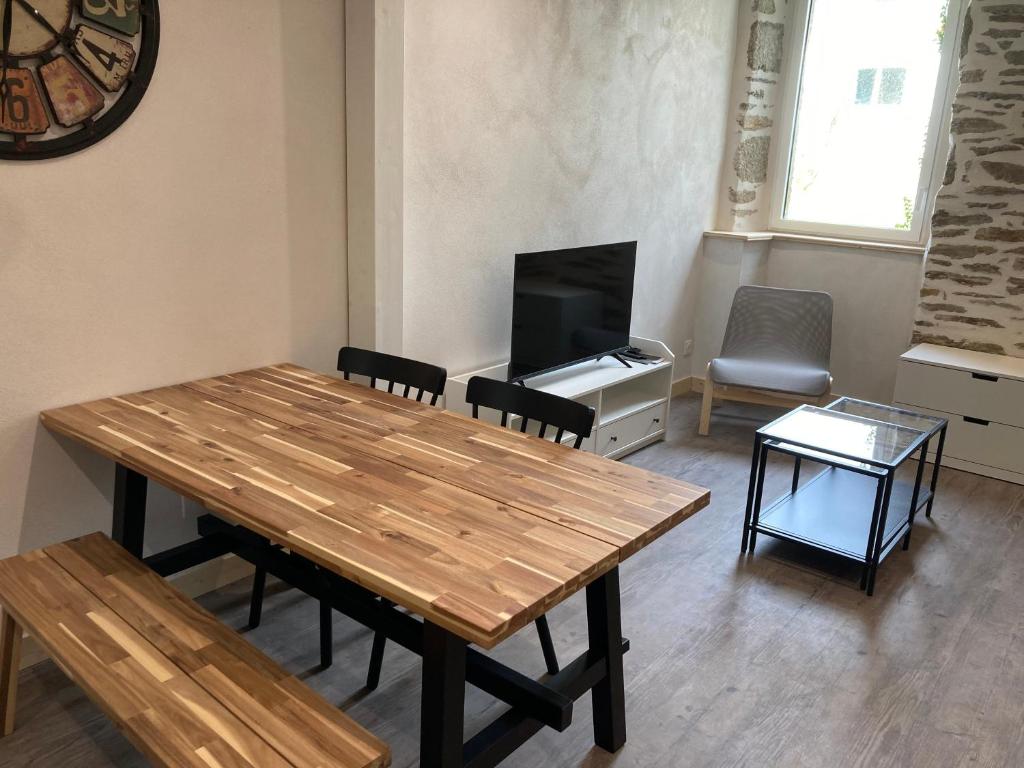 a living room with a wooden table and a television at T2 Le Conquet &quot;Molène&quot; avec parking privé 300m commerces in Le Conquet