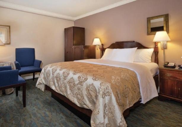 een hotelkamer met een groot bed en een blauwe stoel bij Inn at the Opera in San Francisco