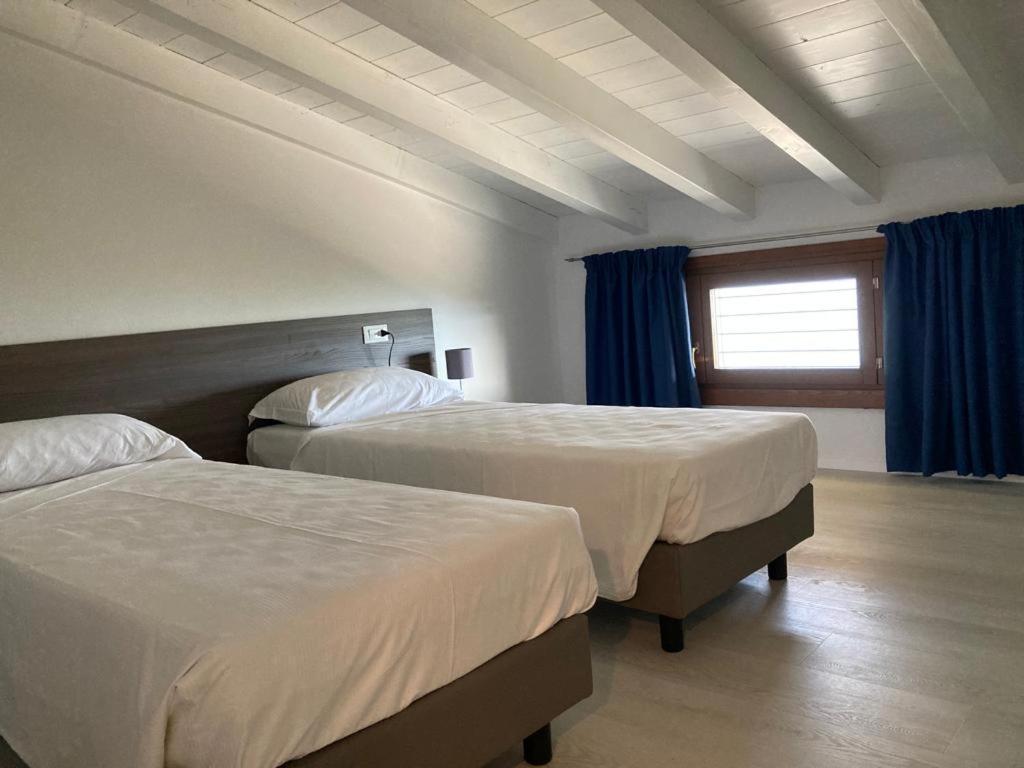 una camera d'albergo con due letti e una finestra di La Casa sul Lago Apartments - Lemon Tree Apartment a Limone sul Garda