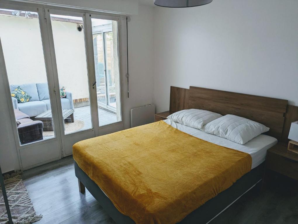 sypialnia z łóżkiem z żółtym kocem w obiekcie Appartements avec terrasse proche métro - Paris à 25min w mieście Créteil