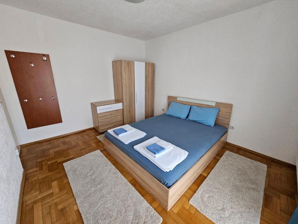 a bedroom with a bed with blue sheets and blue pillows at Central apartment in Prilep in Prilep