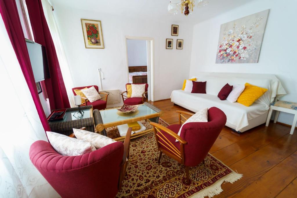 sala de estar con sillas rojas y sofá blanco en Wind & Water, en Delnice