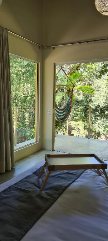 una stanza con un letto e una finestra con un'amaca di Flor de Lis Chalés a Parati