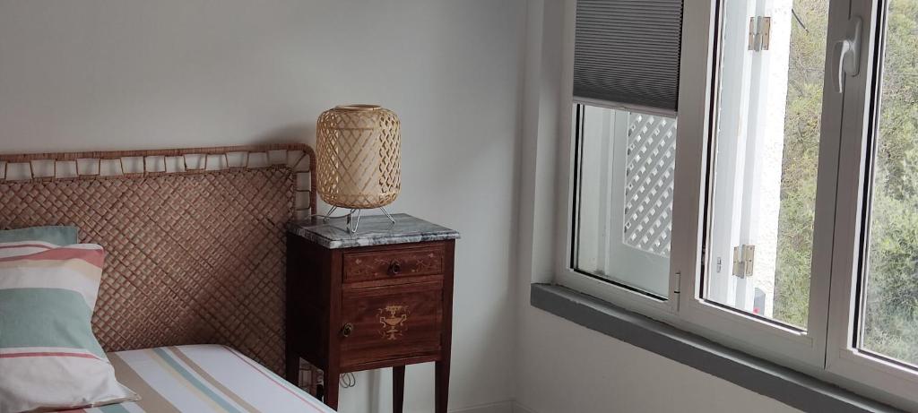 Un dormitorio con una cama y una lámpara en una mesita de noche y una ventana en Cozy Room close to Cascais Downtown en Cascais