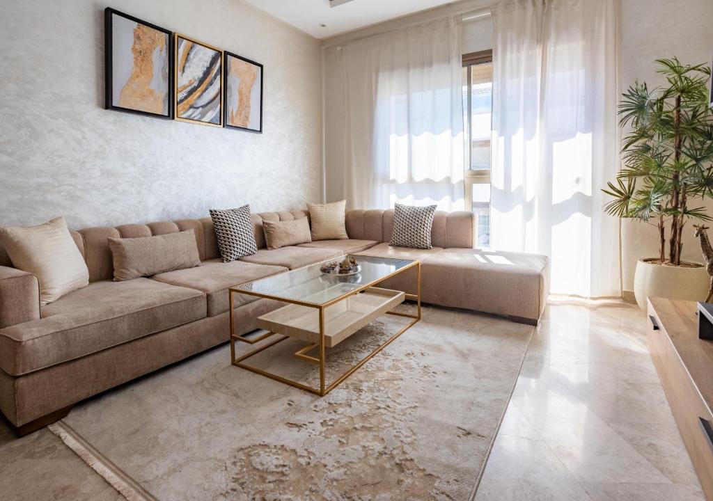 uma sala de estar com um sofá e uma mesa em Modern Charm at Le Joyau du Parc em Mohammedia