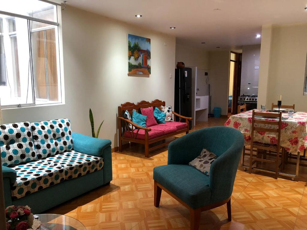 een woonkamer met 2 stoelen en een tafel bij Maria Elena Rooms & Aparments . in Trujillo