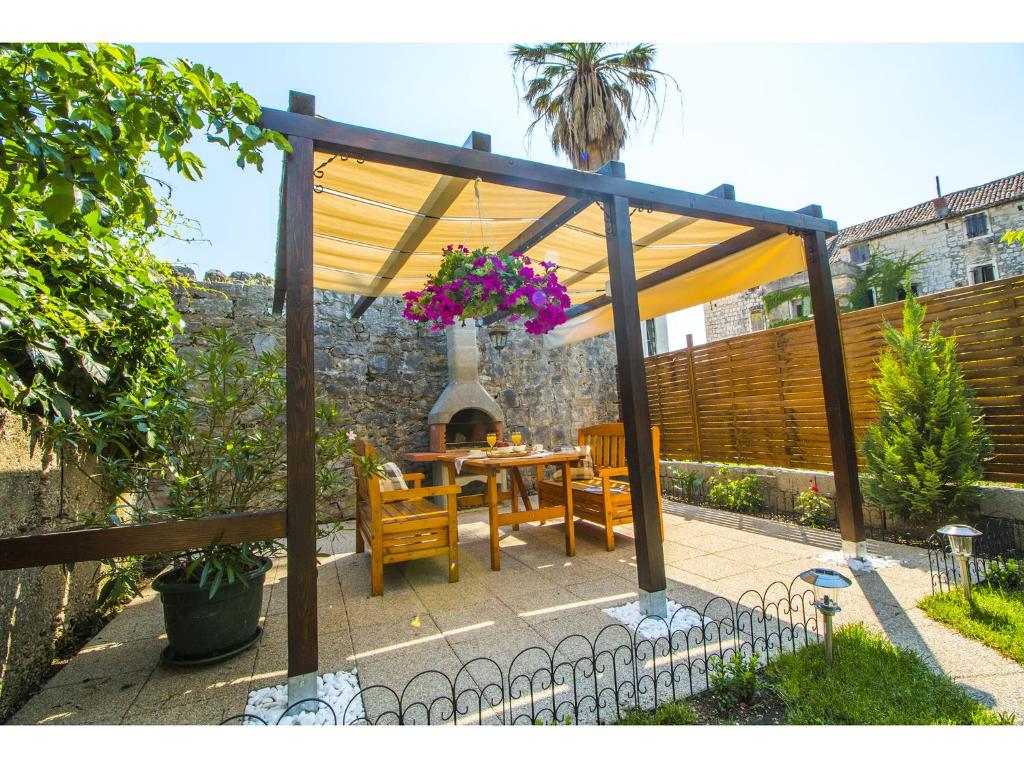 a patio with a table and chairs under a canopy at Apartments Cambi in Kaštela