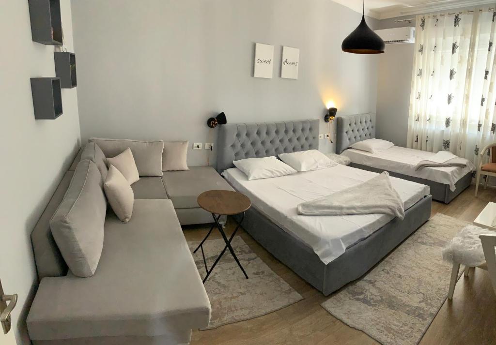 sala de estar con 2 camas y sofá en Elite Apartments Korçë, en Korçë