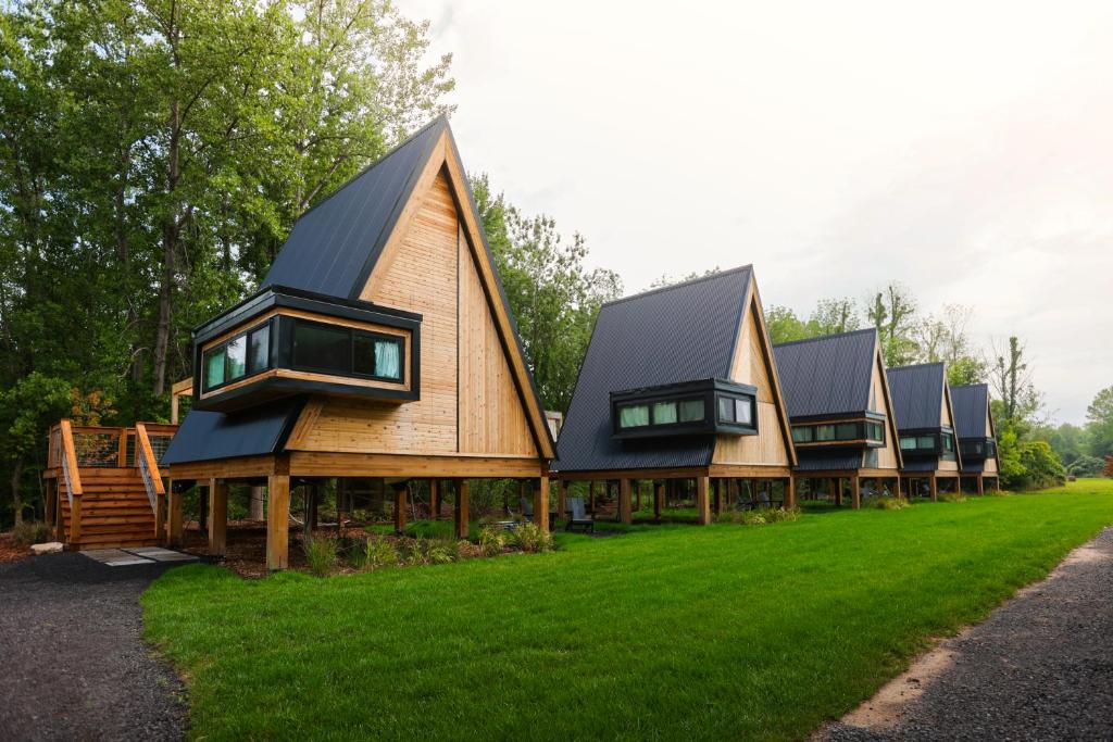 uma fila de casas rústicas com um telhado inclinado em Finger Lakes Treehouse em Sodus