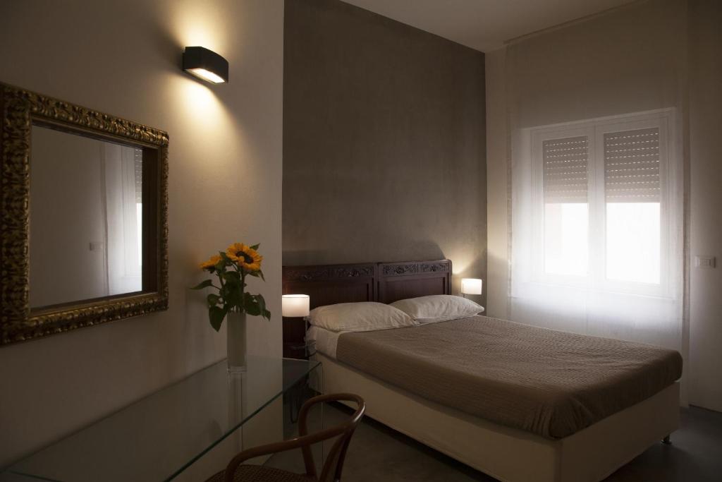 a bedroom with a bed and a mirror and a table at Rosalmar B&B in Palermo