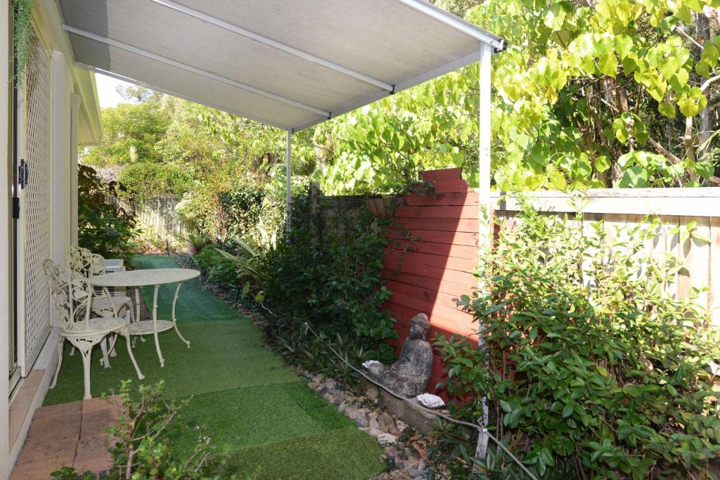 patio con tavolo e ombrellone bianco di Howie's Place Noosa a Noosaville