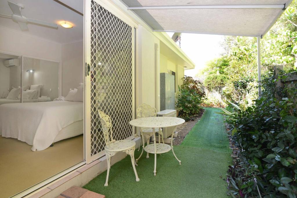 una stanza con un letto, un tavolo e delle sedie di Howie's Place Noosa a Noosaville