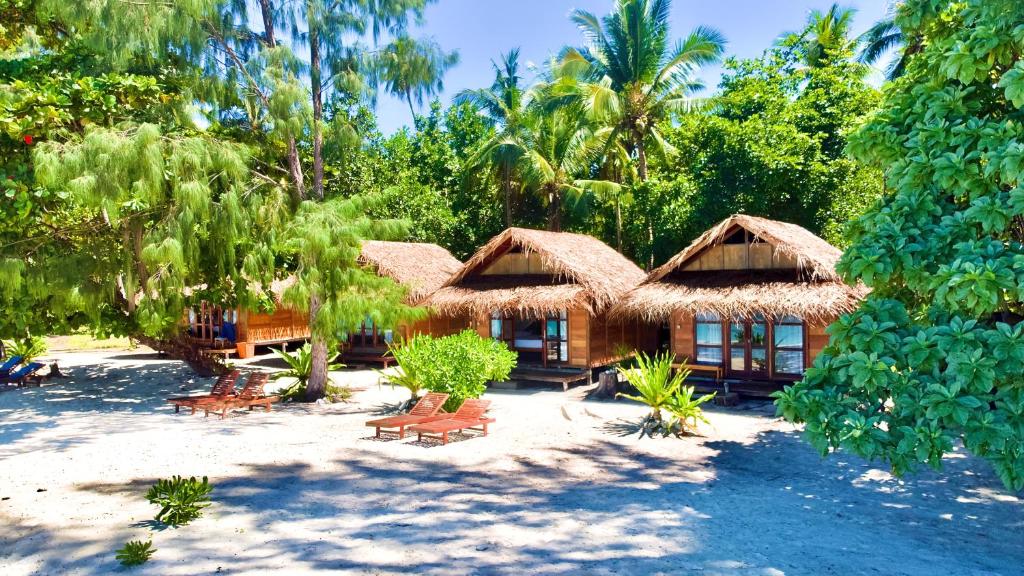 een resort op het strand met stoelen en bomen bij Agusta Eco Resort in Pulau Mansuar