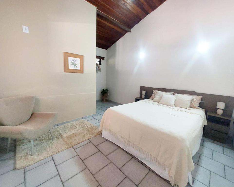 um quarto com uma cama e uma cadeira em La Remonta Residence em Ipiabas