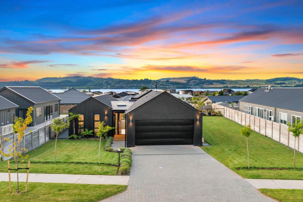 une maison avec un garage noir dans une banlieue dans l'établissement Mellow Yellow, à Taupo