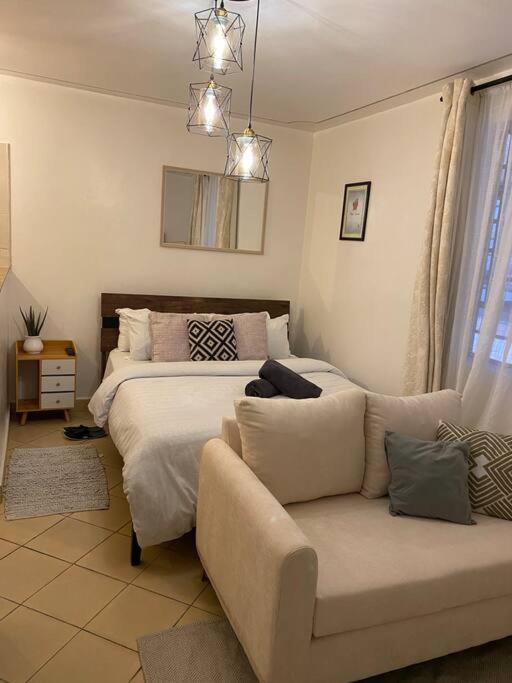 uma sala de estar com uma cama e um sofá em The Manna Place - South B em Nairobi