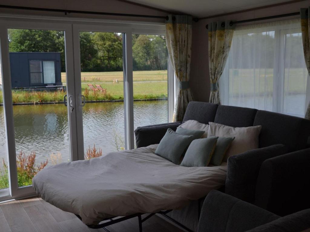ein Bett im Wohnzimmer mit einem großen Fenster in der Unterkunft Brand new chalet on a completely new luxury resort 