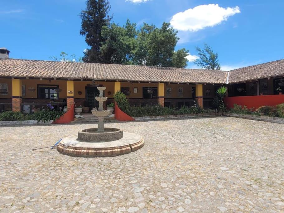 einen Innenhof mit einem Brunnen vor einem Gebäude in der Unterkunft Hacienda San Mateo in Cotacachi