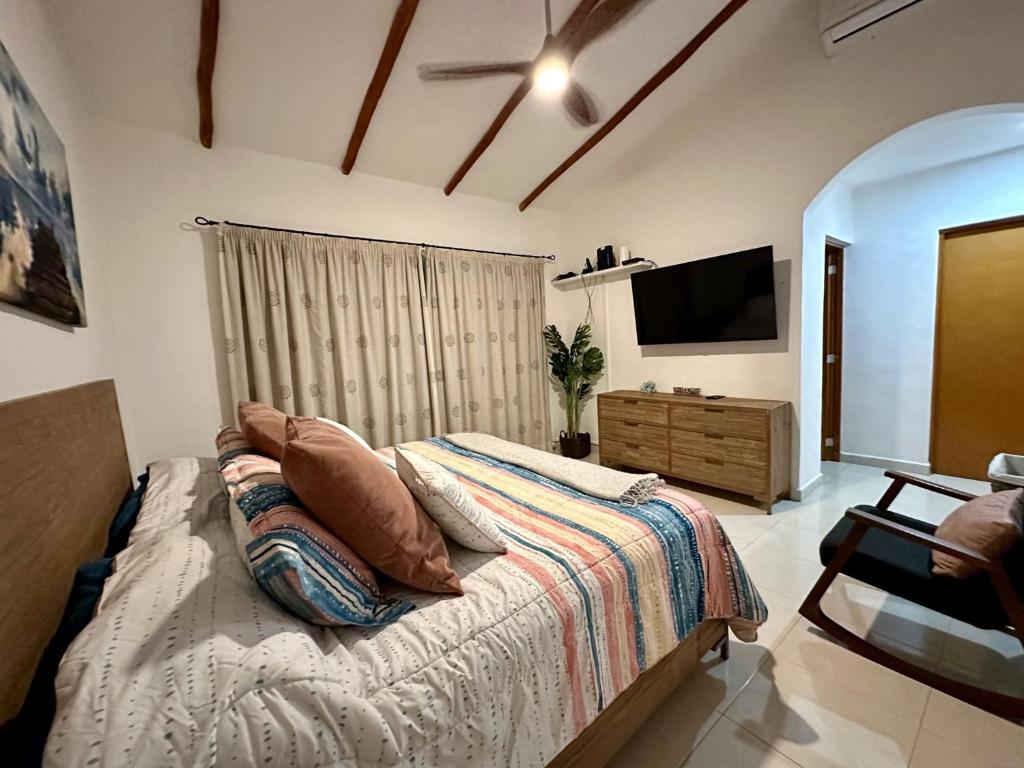 Villa Vaoli في بلايا ديل كارمن: غرفة نوم بسرير وتلفزيون بشاشة مسطحة