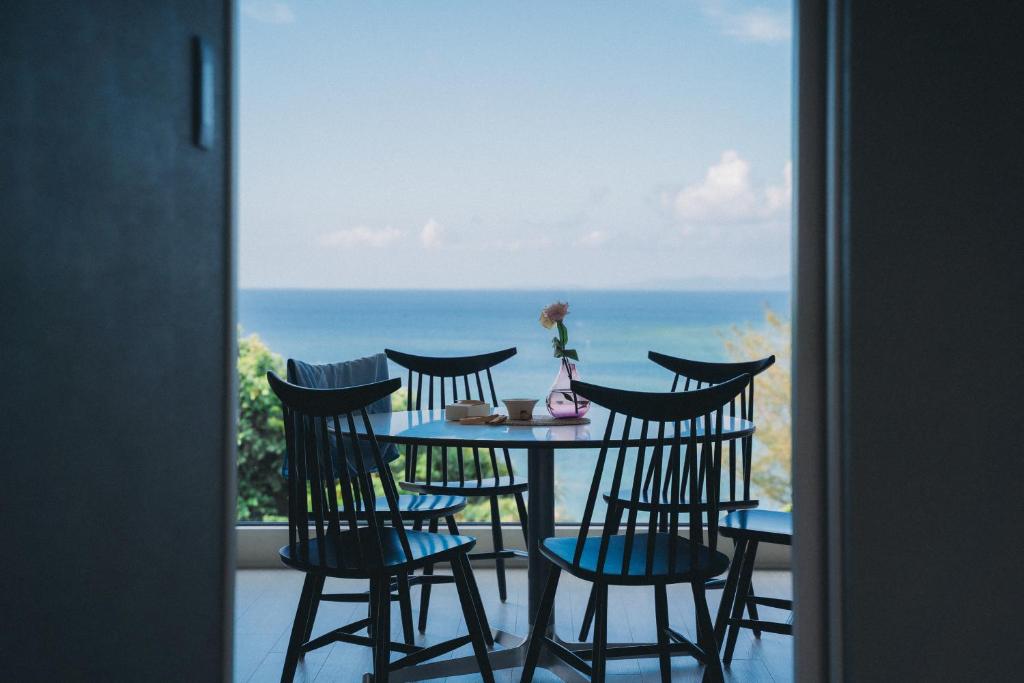 a table and chairs with a view of the ocean at Blue Steak Wonder Yomitan in Yomitan