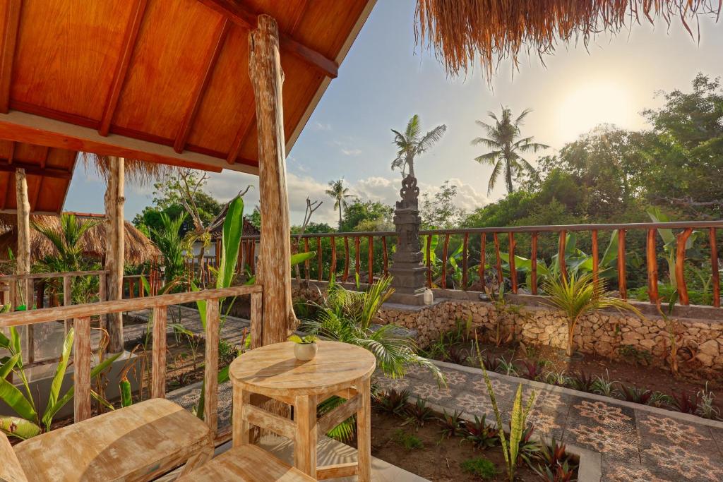 eine Terrasse mit einem Tisch und einem Zaun in der Unterkunft Cassava Penida Cottage in Nusa Penida