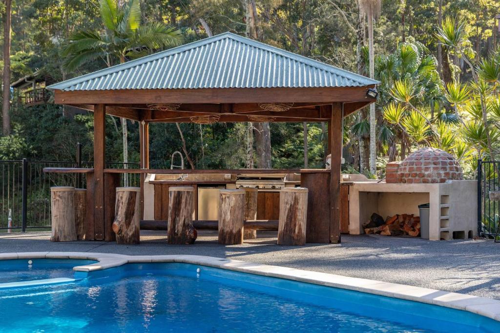 a pavilion next to a swimming pool with a picnic table and a swimming pool at Tambo Lindo in Smiths Lake