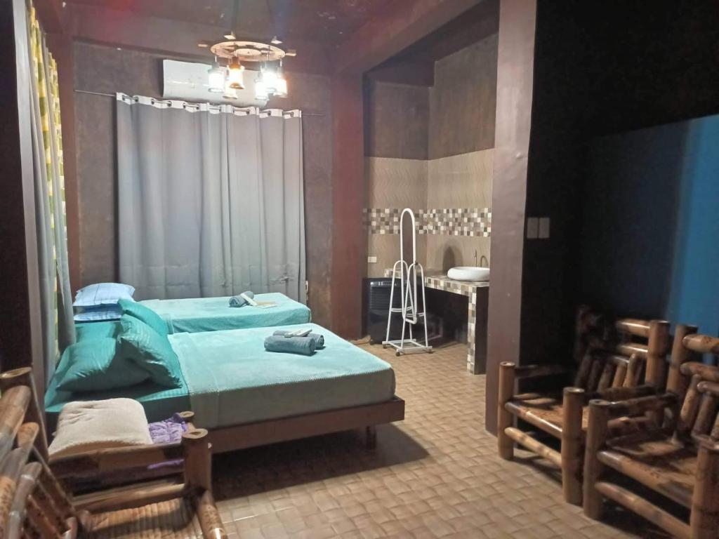 a bedroom with a bed and a table and chairs at Dew Forest - Romblon Airport Hotel in Alcantara