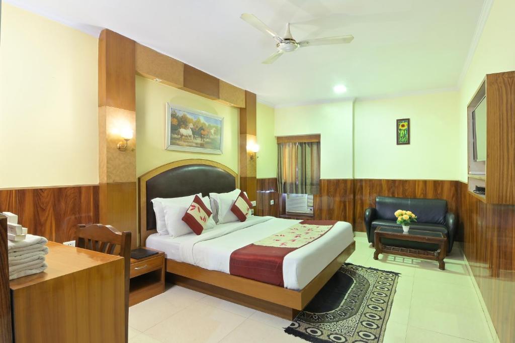 - une chambre avec un lit, un bureau et une chaise dans l'établissement Hotel Castle Blue, à New Delhi
