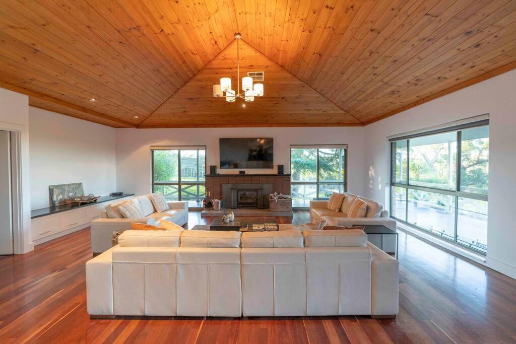 a living room with white furniture and a wooden ceiling at The Hideaway by Gatt Wines in Craneford