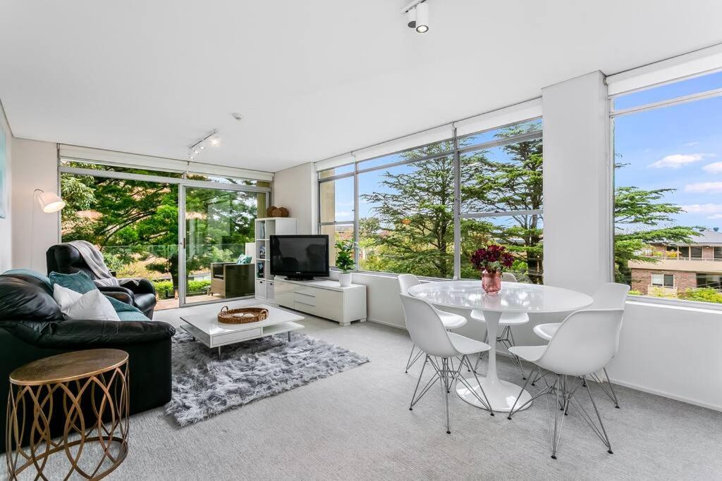 ein Wohnzimmer mit einem Tisch und einem Sofa in der Unterkunft HAR20 - 2 bedroom Harrison Street - Cremorne in Sydney