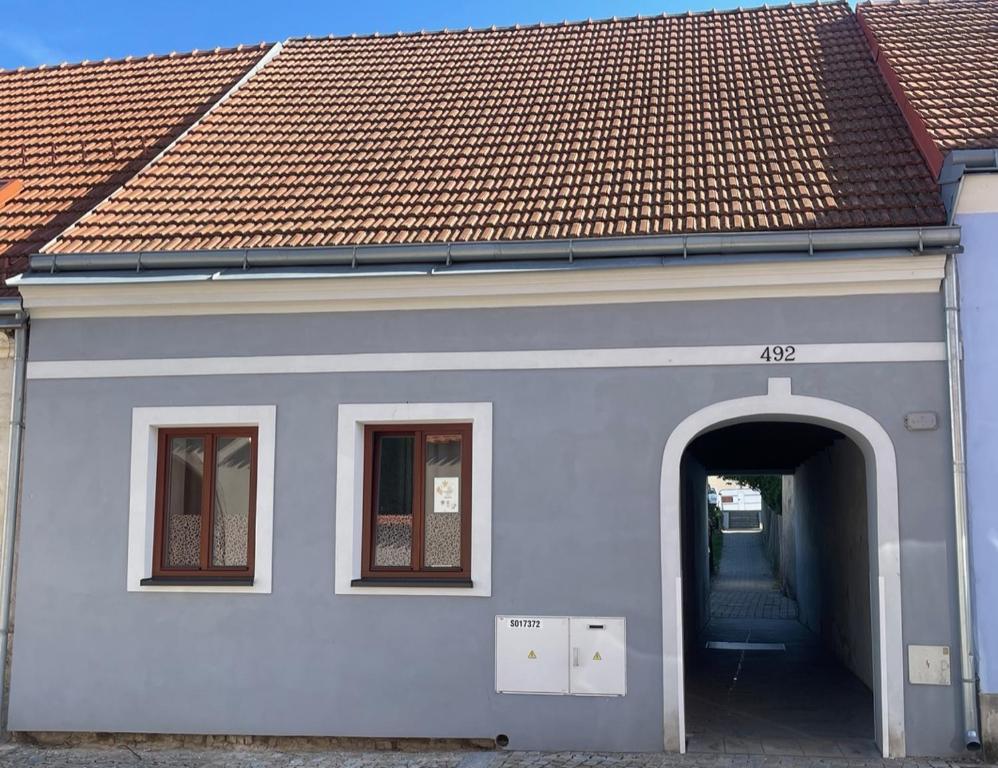 un edificio blanco con arco y techo rojo en Domeček Slavonice, en Slavonice