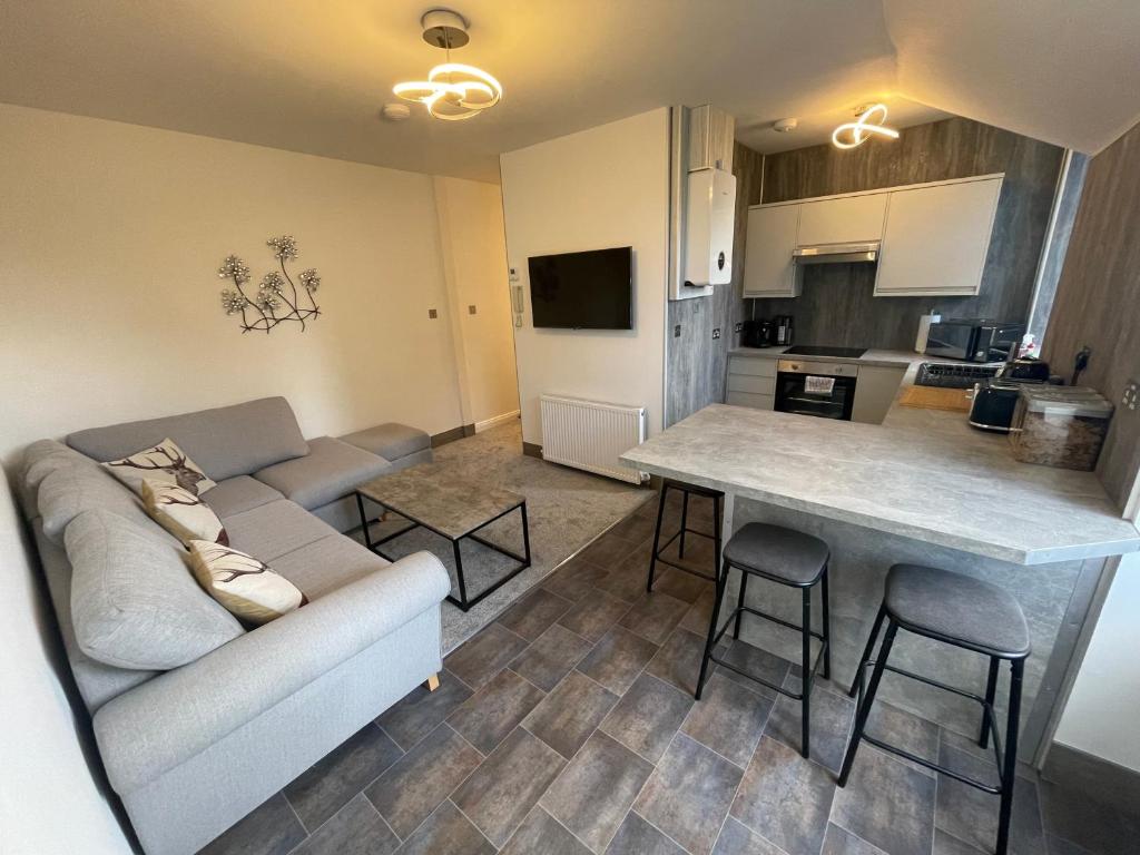 een woonkamer met een bank en een tafel bij Crown àros beag, Ultra City Central 2 bedroom apartment with free parking onsite in Inverness