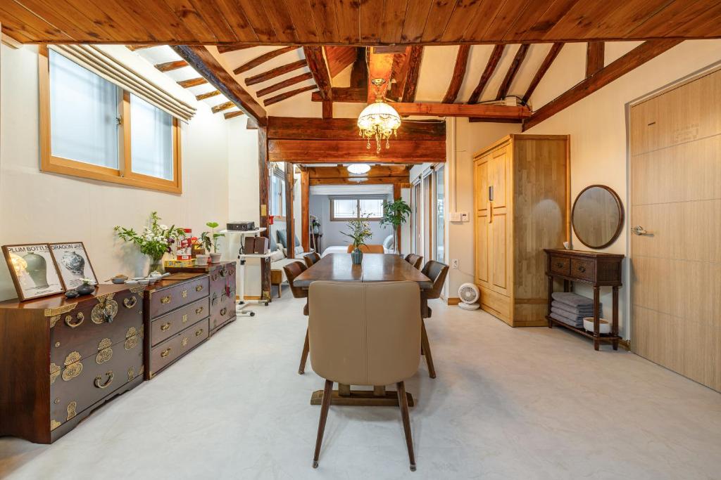 een eetkamer met een tafel en stoelen en houten plafonds bij Memory Stay Seoul Jongro Hanok in Seoul