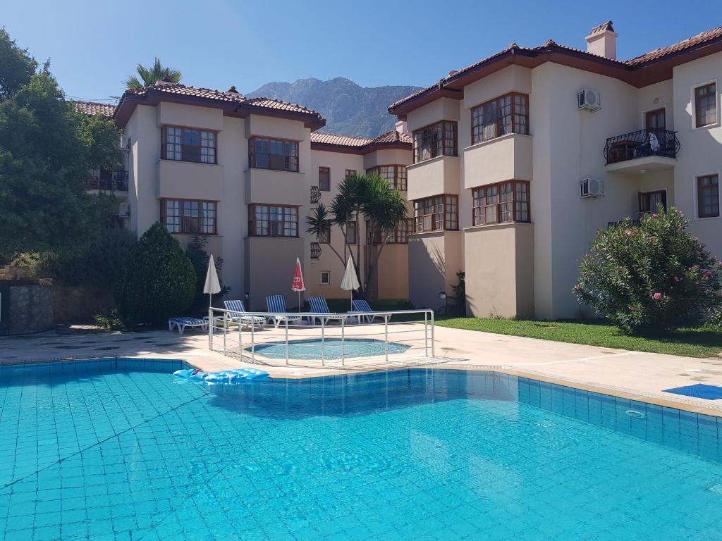 a villa with a swimming pool in front of a house at Dolphin Apartments in Fethiye