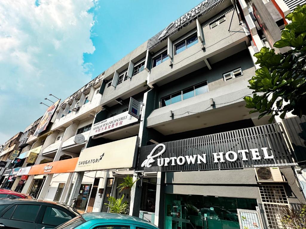 een gebouw met een rij auto's geparkeerd voor het bij De UPTOWN Hotel @ Damansara Uptown in Petaling Jaya
