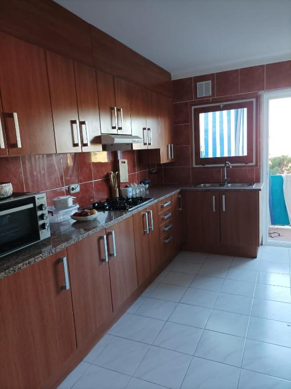 uma grande cozinha com armários de madeira e uma janela em Appartement l’escala em L'Escala