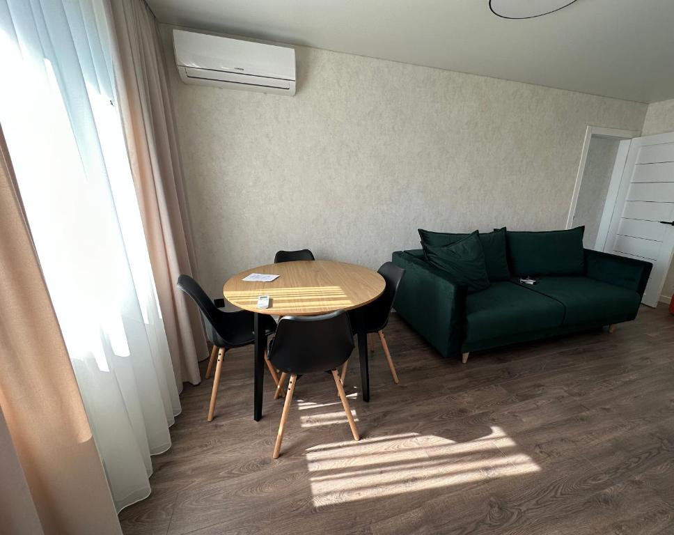sala de estar con sofá verde y mesa en Квартира в историческом центре en Chernihiv