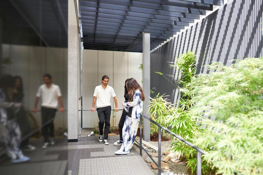 a man and a woman walking down a sidewalk at Hotel Resol Trinity Kanazawa in Kanazawa