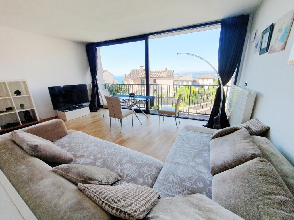 een woonkamer met een bank en een groot raam bij Bella Vista Lux Apartment with private Terace in Koper