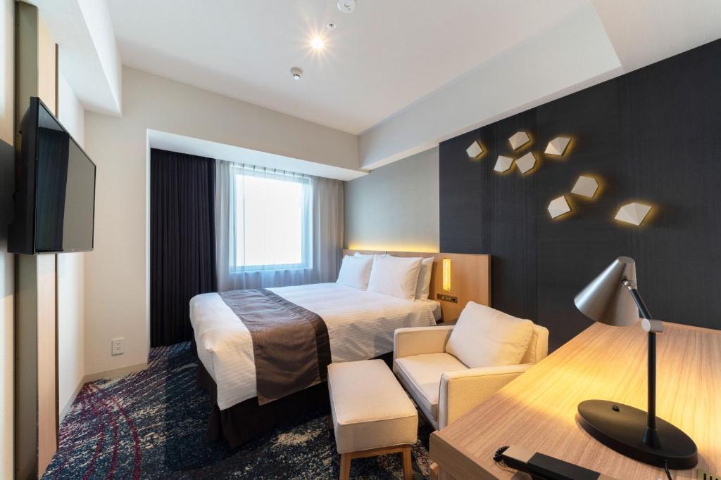 名古屋市にあるホテルJALシティ名古屋 錦のベッドとデスクが備わるホテルルームです。