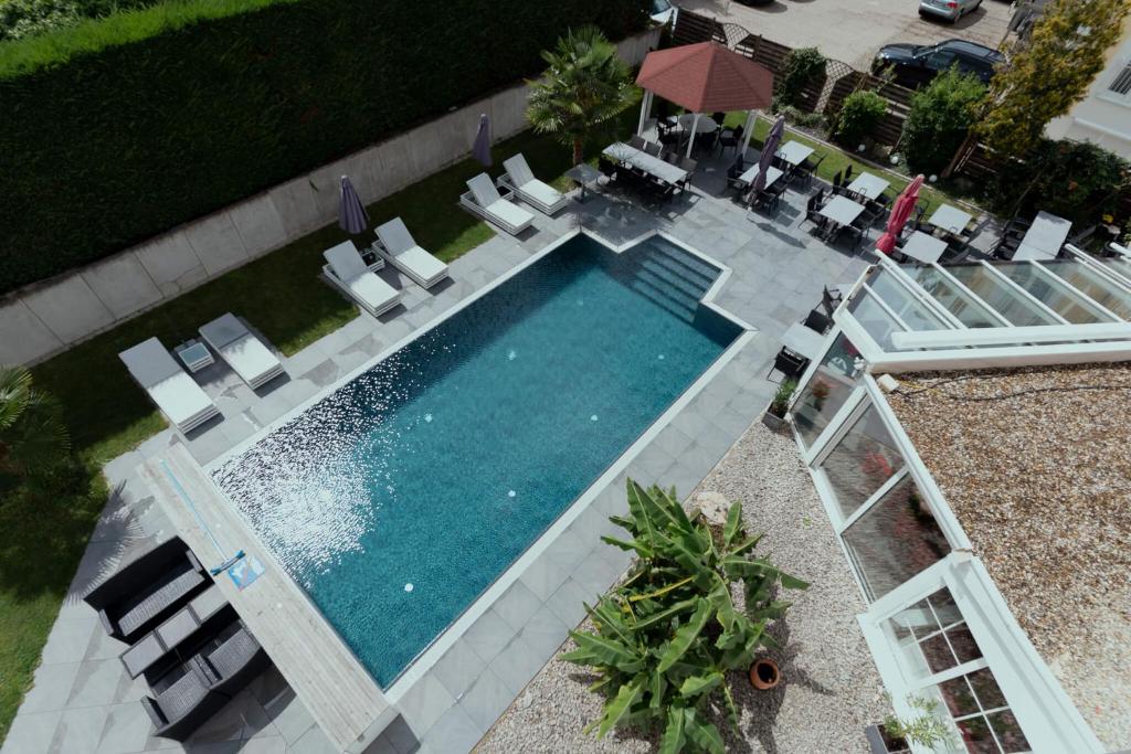 an overhead view of a swimming pool with chairs and an umbrella at Hotel Andante Rust in Rust