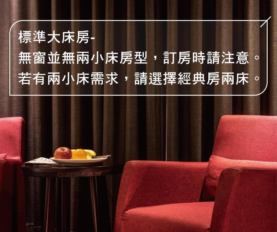 a room with two chairs and a plate of fruit on a table at Chateau-Rich Hotel in Tainan
