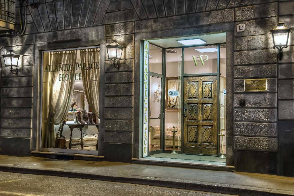 un avant de magasin avec deux miroirs sur un mur de briques dans l'établissement Hotel Atlantic Palace, à Florence